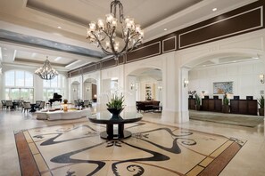 A spacious lobby with a grand chandelier, a piano, and a reception desk. - Summer Breeze - Four Bedroom Villa, Sleeps 8 (Kissimmee)