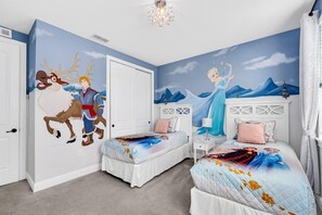 Een slaapkamer met twee bedden, een muurschildering en een kroonluchter.