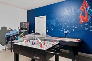 Ein Zimmer mit einem Kicker, Star Wars-Dekorationen und einem Star Wars-Filmplakat an der Wand.