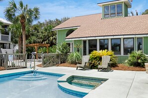 A residential property with a swimming pool, outdoor seating, and a covered patio area. - Hidden Palms (Port St. Joe)