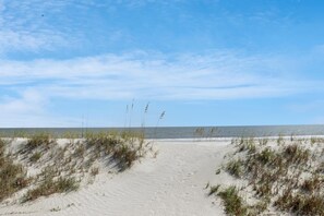 A sandy beach path leading to the ocean with sparse vegetation. - Hidden Palms (Port St. Joe)