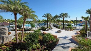 Un resort con piscina, palmeras y un edificio de piedra.