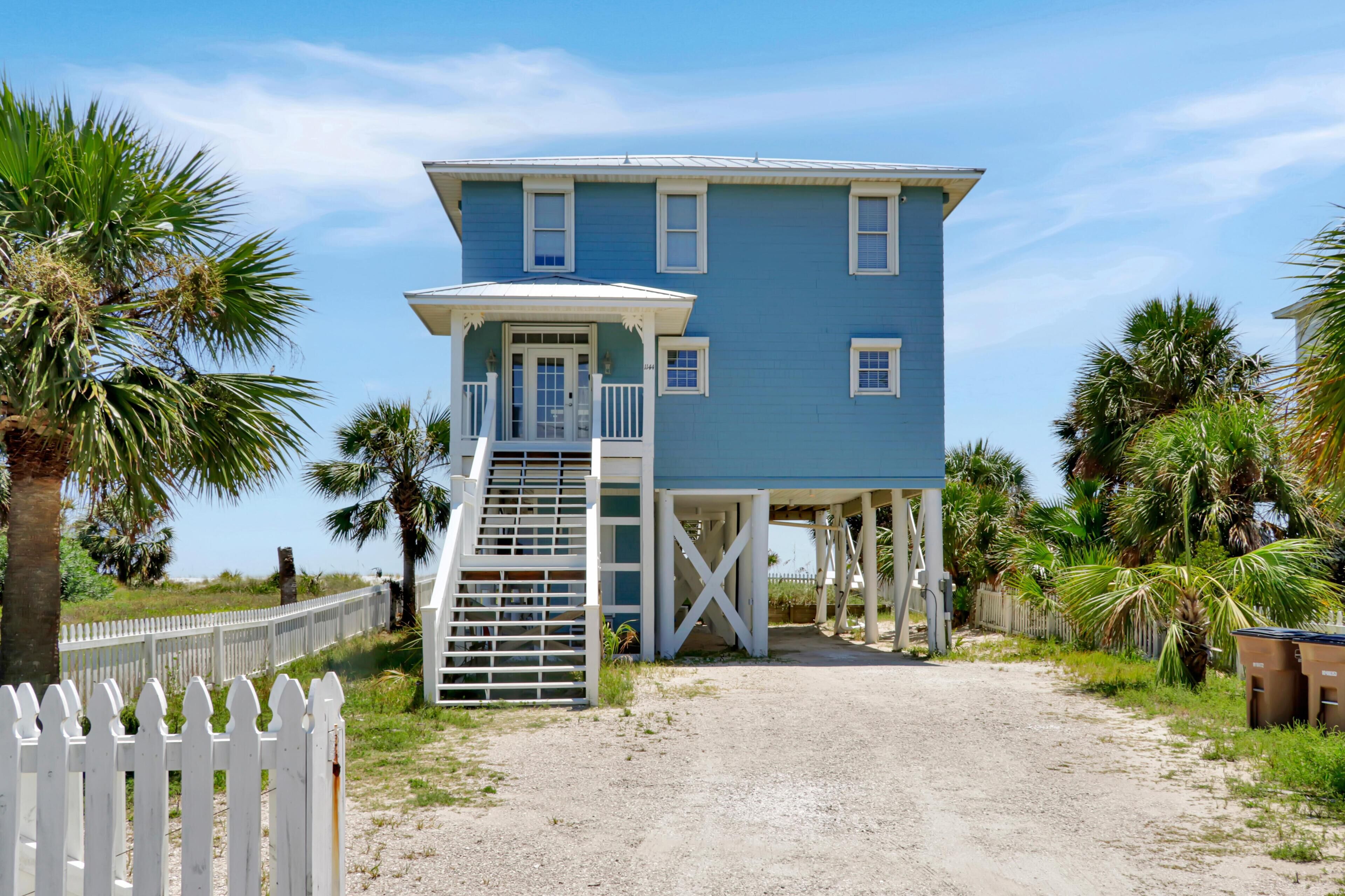 A two-story building with a covered porch and a staircase leading to the entrance.