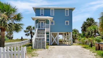 A two-story building with a covered porch and a staircase leading to the entrance.
