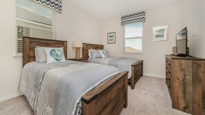 A bedroom with two beds, a dresser, and a television. - Maison Calme - Five Bedroom Villa, Sleeps 13 (Kissimmee)