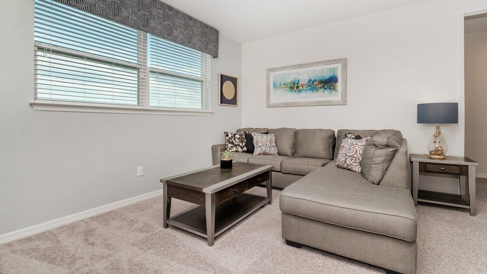 A living room with a sofa, a coffee table, a side table, and a lamp.