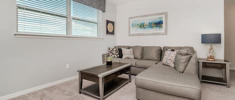 A living room with a sofa, a coffee table, a side table, and a lamp.