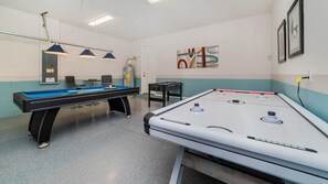 A pool table with a blue felt surface and a white table with a red border. There are two overhead lights and a door in the background. - New Listing! 6 miles Disney/Private Pool and Spa/Flowrider/Teen hangout (Kissimmee)