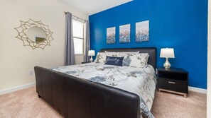 Ein Schlafzimmer mit einem Bett, Nachttischen, einem Spiegel und Bildern an der Wand.