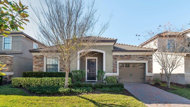 A residential house with a front entrance, a garage, and a well-maintained lawn. - Mickeys Hideout - Four Bedroom House, Sleeps 8 (Kissimmee)