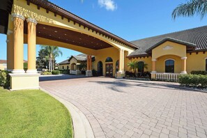 A building with a covered entrance, columns, and a paved driveway. - Morning Mist - Six Bedroom House, Sleeps 12 (Kissimmee)