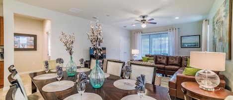 A dining area with a round table, chairs, and decorative vases.