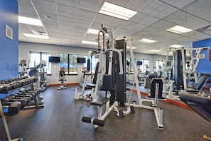 A gym with various exercise equipment, a bench, and dumbbells. - Pooch Parlour - Six Bedroom House, Sleeps 14 (Kissimmee)