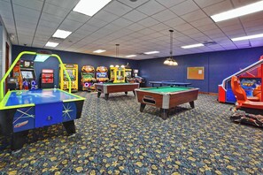 Ein Raum mit Billardtisch, Kicker und verschiedenen Spielautomaten.