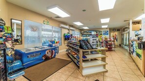 Ein Kiosk mit einer Blue Bunny Eispräsentation, Regalen voller Snacks und einem Kühlschrank für Bud Light.