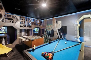 Ein Raum mit Billardtisch, Kicker und Spielautomaten.