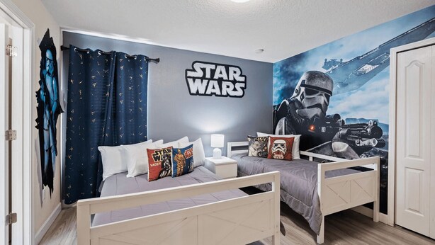Makuuhuoneessa on Star Wars -teemalla koristeltu seinä, kaksi sänkyä ja vaatekaappi.