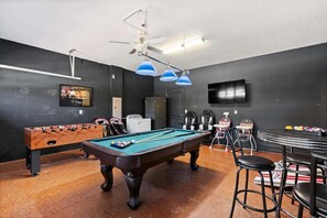 A billiards room with a pool table, foosball table, and seating area. - The Grand Slam - Eight Bedroom Apartment, Sleeps 19 (Kissimmee)