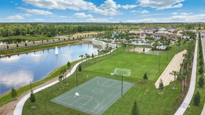 A residential area with a basketball court, a pond, and houses. - The Forever Home - Five Bedroom House, Sleeps 12 (Kissimmee)