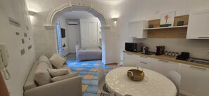 A compact living space with a kitchenette, a dining area, and a bedroom. - The Vault Apartments Vietri - Authentic Amalfi Coast (Vietri sul Mare)