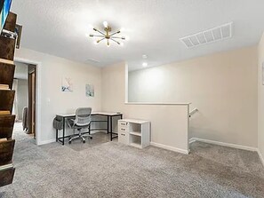 Une pièce comprenant un bureau, une chaise et une étagère.