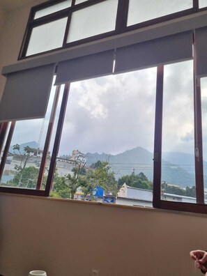 A room with a large window overlooking a mountainous landscape.