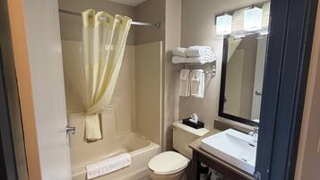 A bathroom with a bathtub, toilet, and sink.