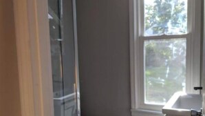 Une salle de bain avec des toilettes, une fenêtre et un espace douche.