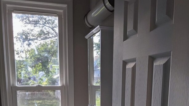 A bathroom with a window, a sink, and a door.