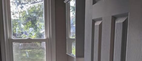 Un baño con ventana, lavamanos y puerta.
