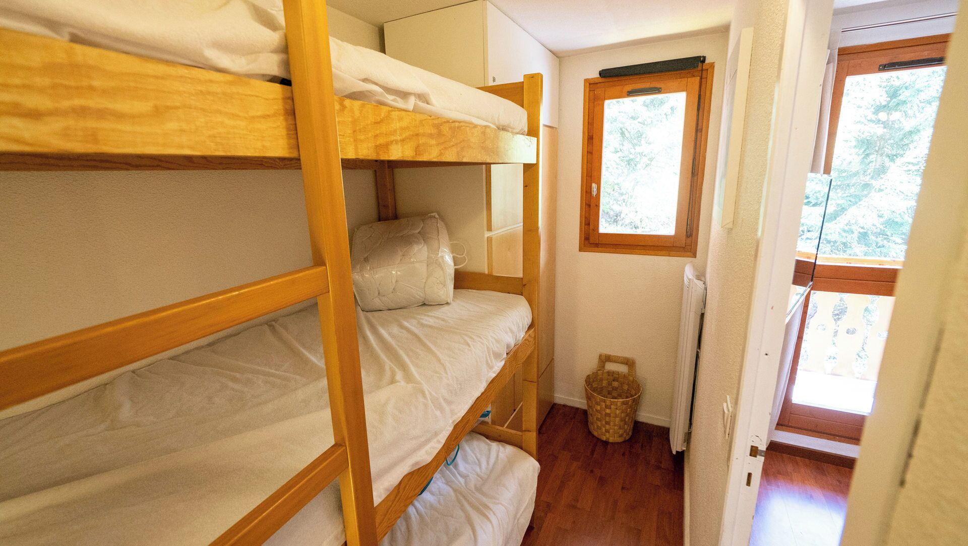 A bunk bed room with a window and a radiator.