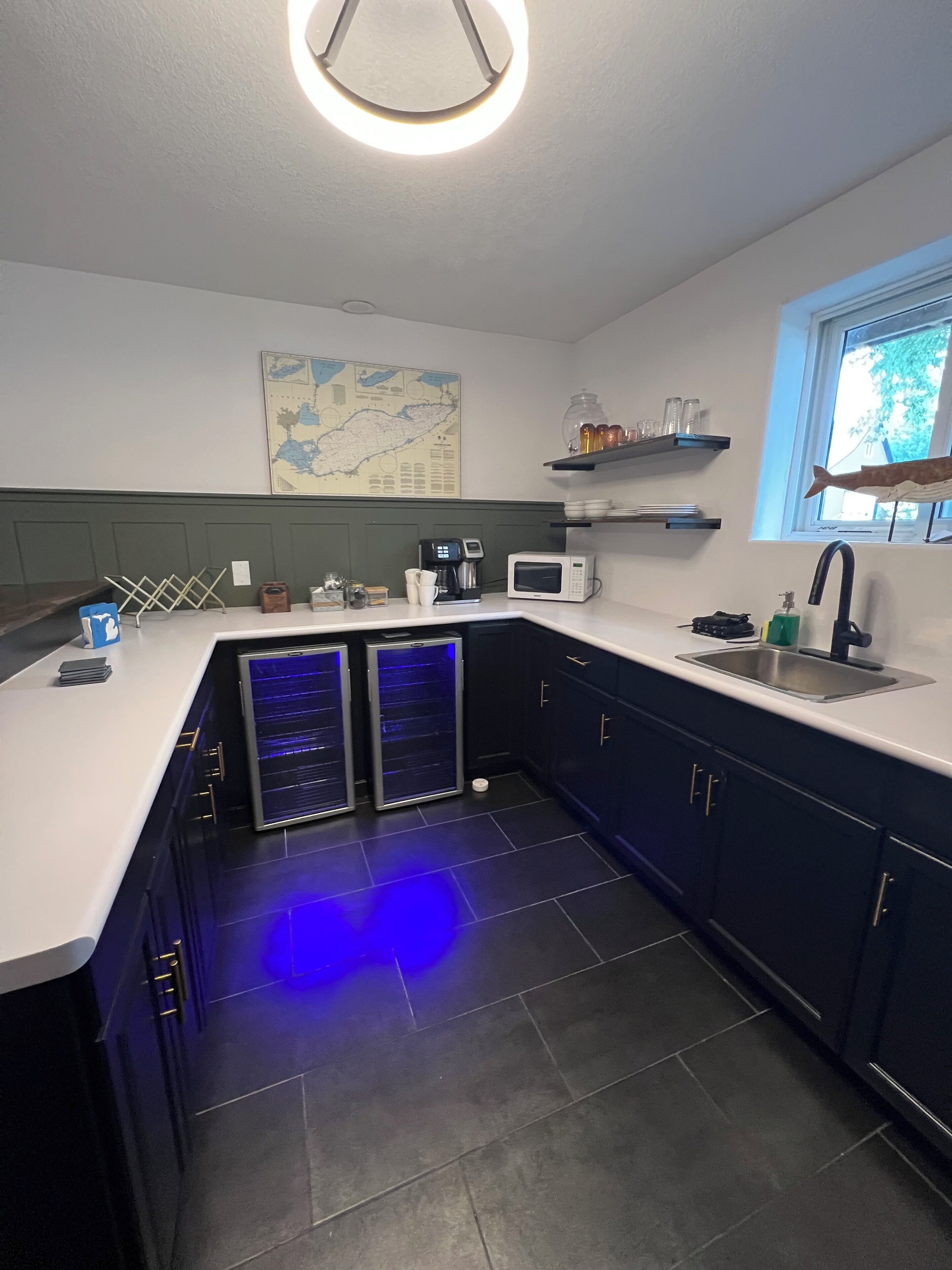Cocina moderna con isla integrada, microondas, cafetera y pileta.