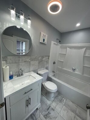 A bathroom with a sink, toilet, and bathtub. - Amazing Boston Downtown City View Rooms (BOSTON)