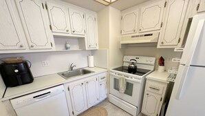 A kitchen with white cabinetry, a dishwasher, a stove, and a refrigerator.