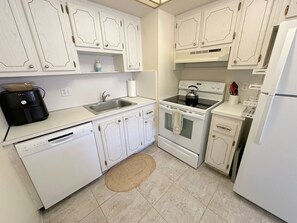 A kitchen with white cabinetry, a dishwasher, a stove, and a refrigerator.