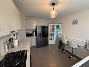 A modern kitchen with a gas stove, a refrigerator, a microwave, and a coffee machine. - House with a completely private pool and hot tub near Paris (bures sur yvette)