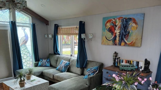 A living room with a sofa, a coffee table, a painting of an elephant, and a statue.