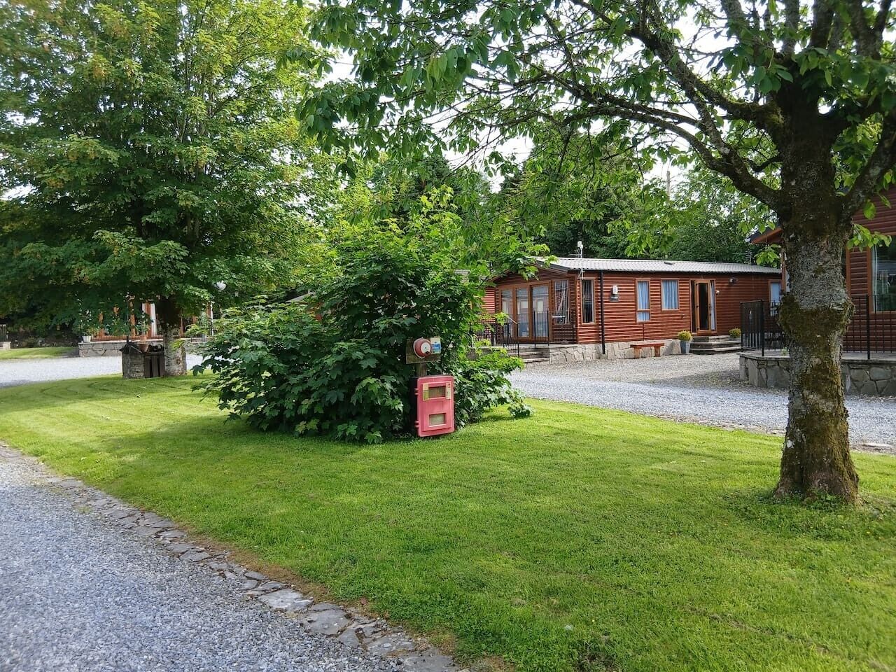 A red building with a gravel driveway and a well-maintained lawn.