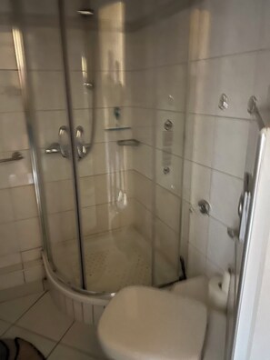 A bathroom with a glass-enclosed shower, a toilet, and a sink. - Büsum High-Rise, 1st Floor: Right on the dike—Perlebucht is just a stone's throw away (Büsum)