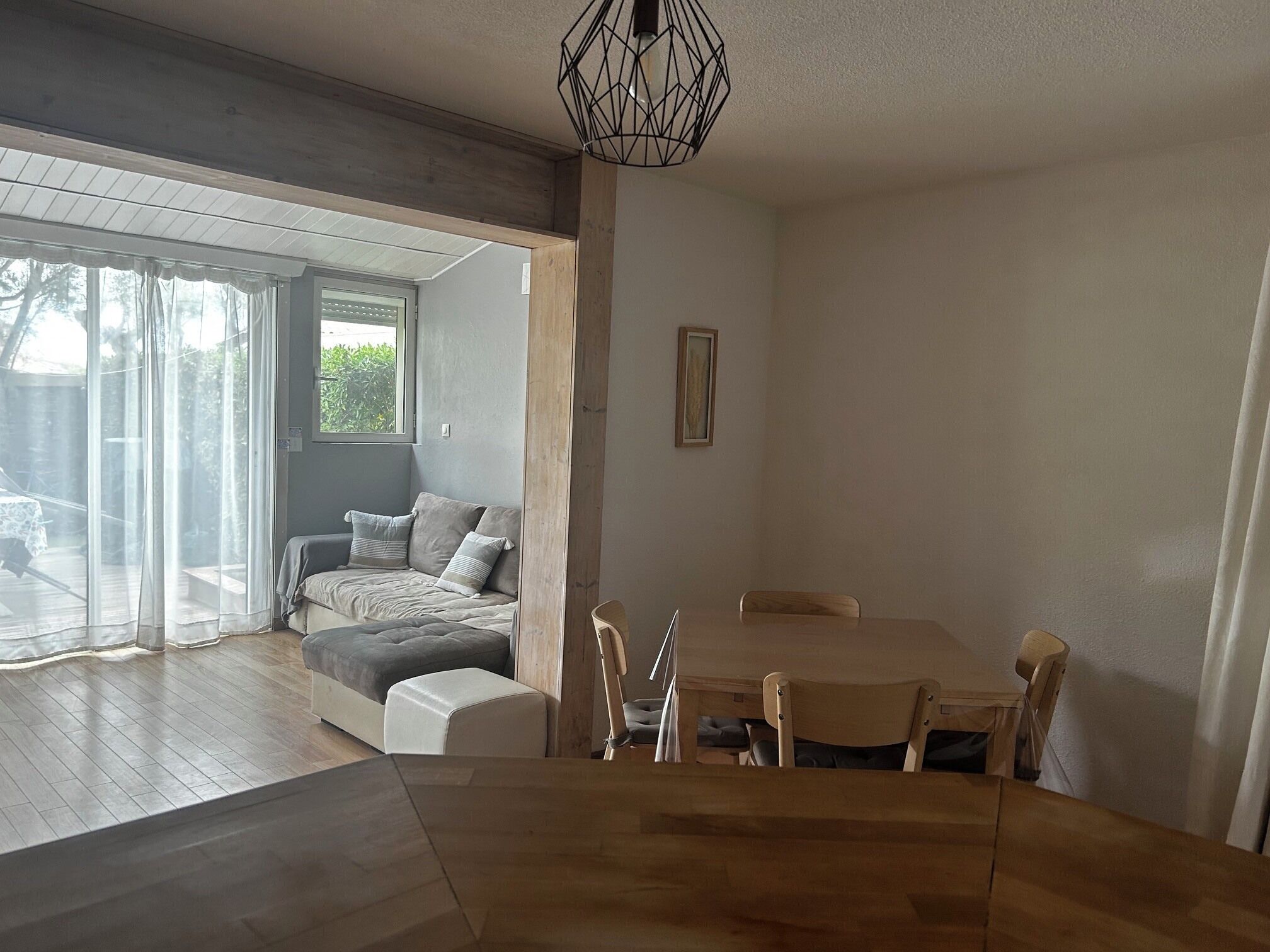 Un interior moderno con comedor, sofá y un amplio ventanal.