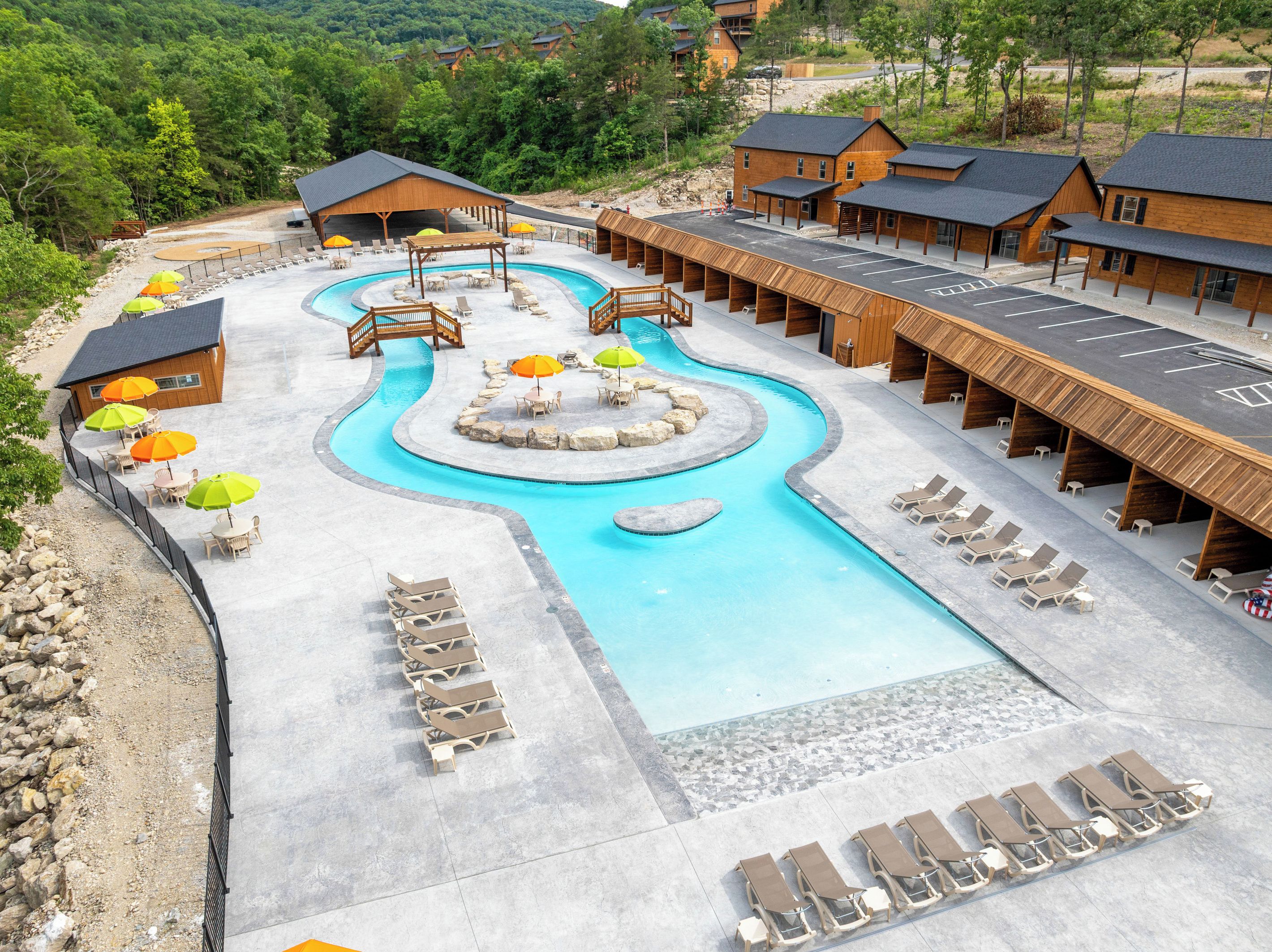 Ein Resort mit Swimmingpool, Liegestühlen und Holzbungalows.