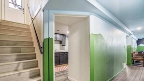 A staircase leading to a kitchen area with cabinets and a window. - Aloha Springs! Private Heated Pool & Hot Tub (Colorado Springs)