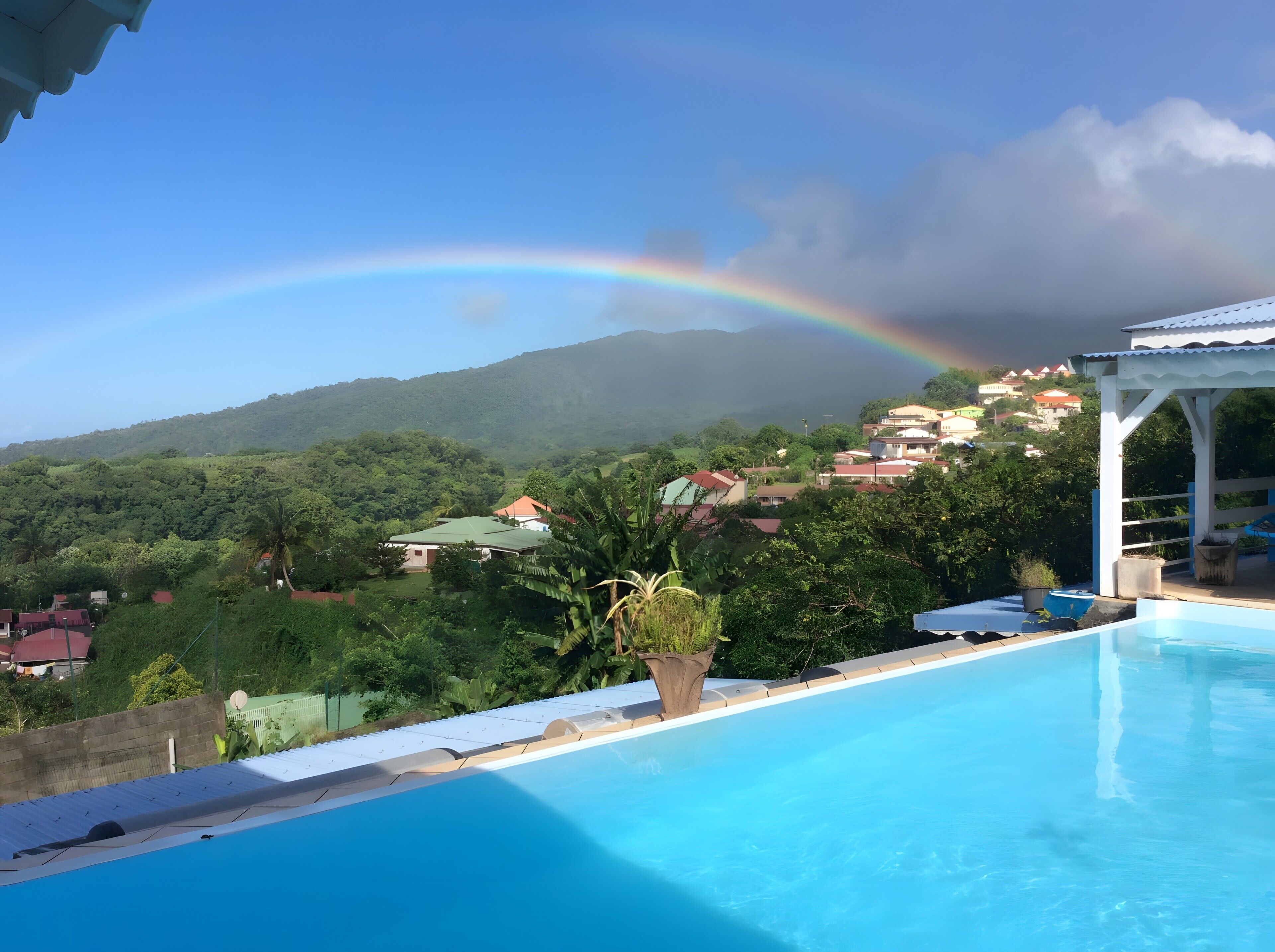 A swimming pool with a view of a village and mountains.