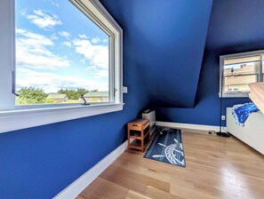 A room with a large window, wooden flooring, and a view of greenery outside. - Luxury Coastal Apt Above Bakery,Near Beach, Acadia (Hancock)