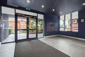 Ein modernes Interieur mit Glastür-Eingang, einem wandmontierten Verzeichnis und Blick auf die Straße.