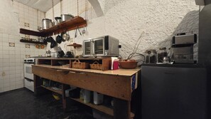 A kitchen with a wooden table, hanging pots, a microwave, and a refrigerator. - Mansion with a private garden in downtown Tepoztlán (pet-friendly) (Tepoztlán)