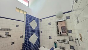 A bathroom with blue and white tiles, a mirror, a toilet, and a sink.