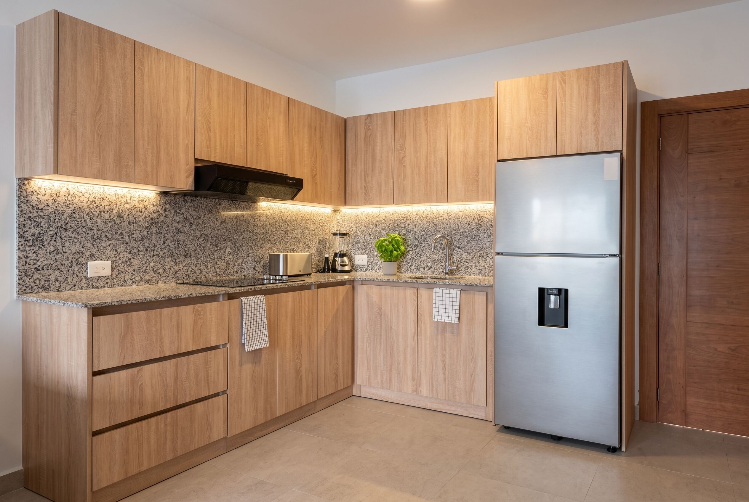 Una cucina moderna con mobili in legno, piani in granito, un frigorifero in acciaio inossidabile e un forno integrato.