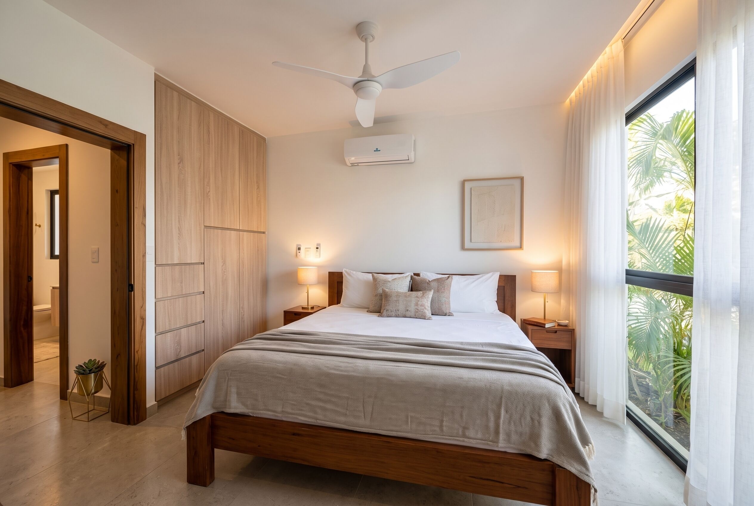 Une chambre à coucher avec un lit, des lampes de chevet, un ventilateur de plafond et une fenêtre avec des rideaux.