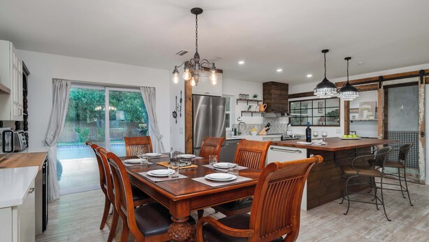 Comedor con mesa de madera dispuesta para seis personas, rodeada de sillas.